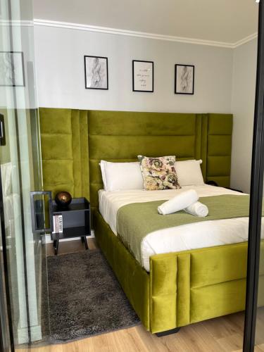 Un dormitorio con una cama con cabecero verde. en Ellipse waterfall midrand, en Midrand