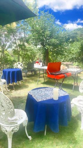 a table with a blue table cloth and chairs at ガーデンリゾート 潮美庵 in Hatsukaichi