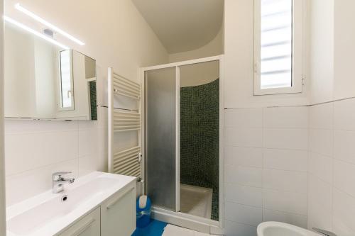 une salle de bain blanche avec une douche et un lavabo dans l'établissement Wonderful Apartment on Sea, à Nice