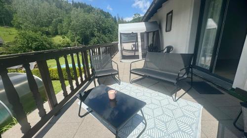 a patio with a table and chairs on a balcony at CHATA POD HORAMA in Benecko