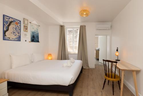 une chambre avec un lit, un bureau et une fenêtre dans l'établissement Le Grand Authentique, à Carcassonne