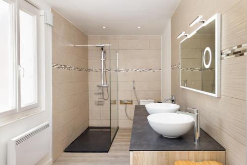une salle de bain avec deux lavabos et une douche en verre dans l'établissement Le Grand Authentique, à Carcassonne