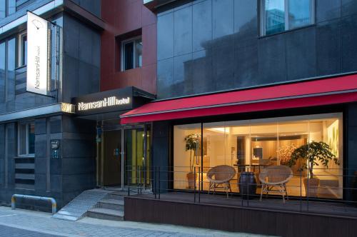 a restaurant with two chairs in a window at Namsan Hill Hotel in Seoul