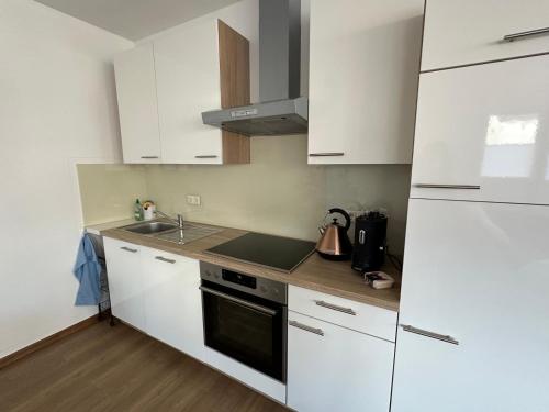 a kitchen with white cabinets and a sink and a stove at Wohnung in Mülheim-Kärlich in Mülheim-Kärlich