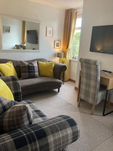 a living room with a couch and a chair at Free Parking, Near Airport, Aberdeen Uni and ARI in Aberdeen