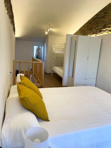 a bedroom with a bed with a yellow pillow on it at A Casiña do Rey Casita junto a la playa de Cabañas in Cabañas