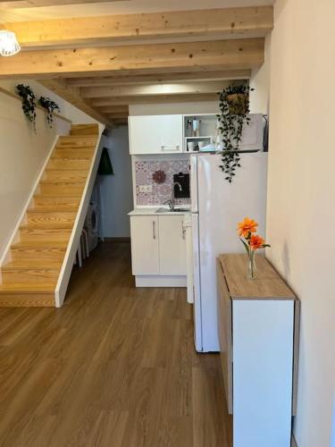 a kitchen with a white refrigerator and a staircase at A Casiña do Rey Casita junto a la playa de Cabañas in Cabañas