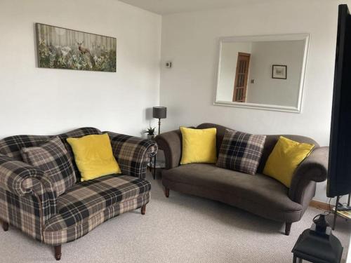 a living room with two couches and a mirror at Free Parking, Near Airport, Aberdeen Uni and ARI in Aberdeen