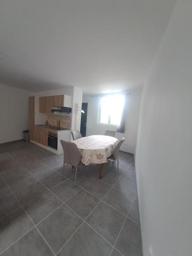 une cuisine et une salle à manger avec une table et des chaises dans l'établissement T2 Concoules, à Concoules