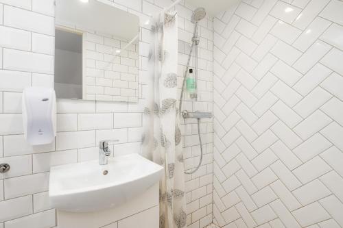 un bagno bianco con lavandino e doccia di Pärnu Old Town Apartment with Patio a Pärnu