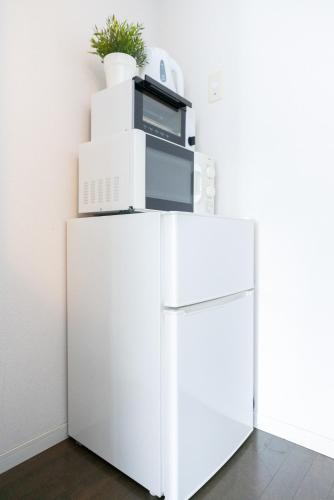 a microwave on top of a white refrigerator at Yakuin apartment in Fukuoka