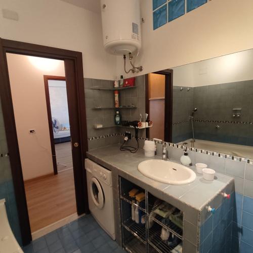 a bathroom with a sink and a washing machine at Stella Marina in Giardini Naxos