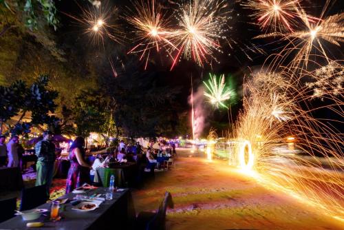 a crowd of people sitting at tables watching fireworks at Samed Tropical Resort in Ko Samed