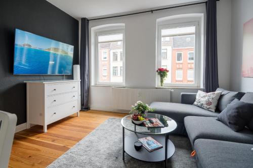 a living room with a couch and a table at TOP 2 Zimmer Altbauwohnung in Kiel Mitte 24-7 Check In in Kiel