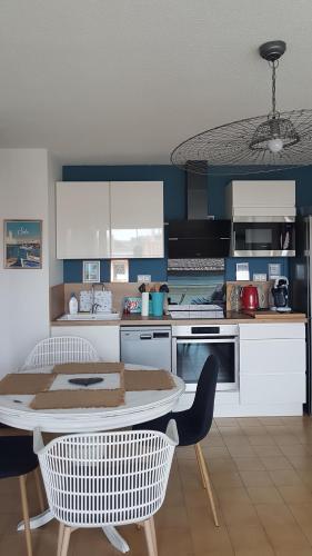 une cuisine avec une table et des chaises dans l'établissement Le Beausoleil, à Sète