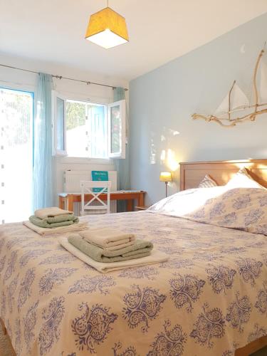 a bedroom with a bed with two towels on it at Villa Panorama Garden Chorto in Chorto