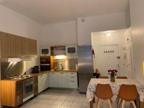 une cuisine avec une table avec des chaises et un réfrigérateur dans l'établissement The French Coastal Retreat by J - Central, 5 Mins to SEA, Tram, Train, AC, WiFi, à Nice