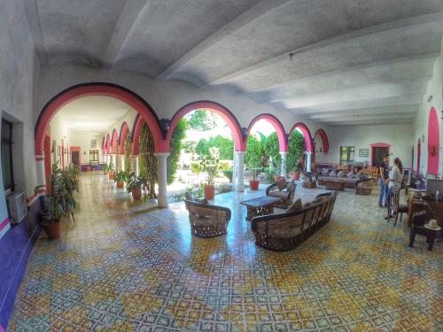 a large room with arches and tables in a building at Hacienda Santa Cruz Del Fuerte in El Fuerte
