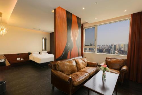 a hotel room with a couch and a bed at Hotel The Designers Hongdae in Seoul