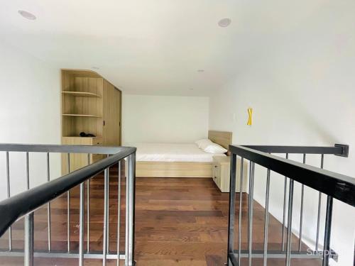 a small room with a bed and a staircase at KSI-HOME Đà Lạt in Khu Chi Lăng