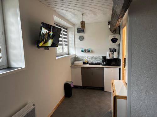 Il dispose d'une cuisine avec une télévision murale à écran plat. dans l'établissement Tranquille, à Fécamp