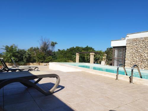 a patio with a table and a swimming pool at RizzoRelax B&b io mammata e tu in Capilungo