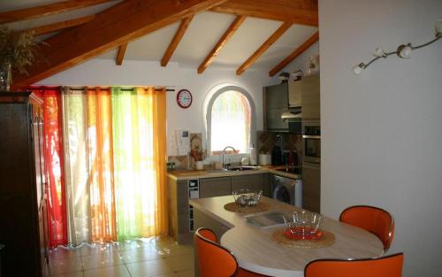 - une cuisine avec une table, des chaises et un évier dans l'établissement Le mazet, à Saint-Mandrier-sur-Mer