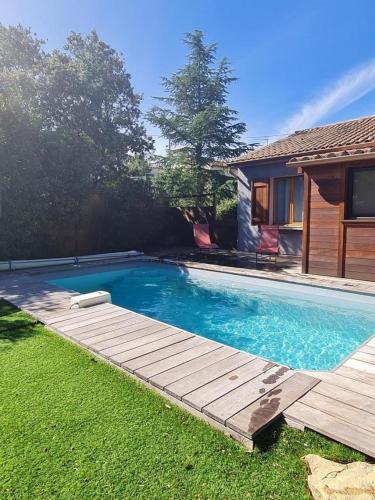une piscine avec une terrasse en bois à côté d'une maison dans l'établissement Gîte location de vacances : G2735, à Saint-Maximin-la-Sainte-Baume