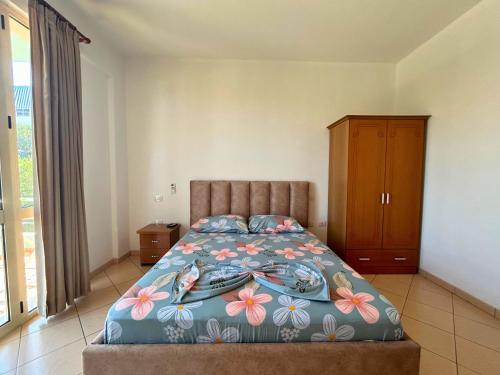 a bedroom with a bed and a wooden cabinet at Onis Sea View Apartments in Orikum