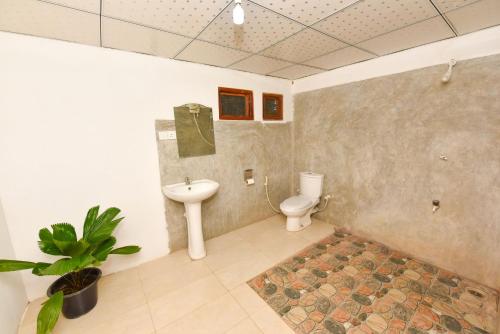 a bathroom with a toilet and a sink at Elephant Trio Sigiriya in Sigiriya