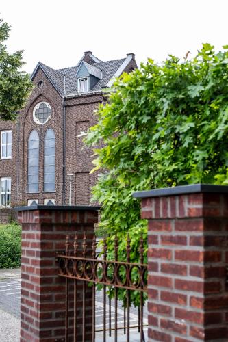 a brick fence in front of a brick building at BB aan de kapel in Roermond