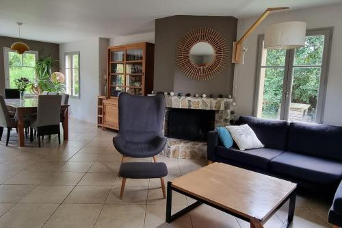 un salon avec un canapé bleu et une table dans l'établissement BRETAGNE proche mer maison 5 chambres, à Pleurtuit