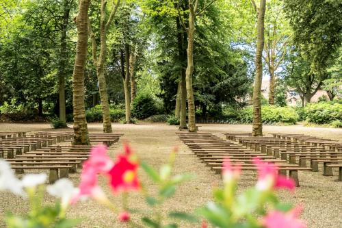 a row of bleachers in a park with pink flowers at BB aan de kapel in Roermond