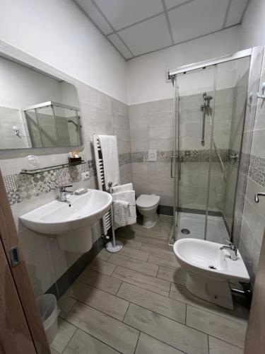 a bathroom with a sink and a shower and a toilet at La Suite in Cassino