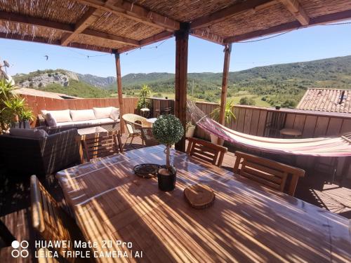 - un hamac sur une terrasse avec une table et un hamac dans l'établissement L'étape Bien être chambre triple, à Camps-sur-lʼAgly