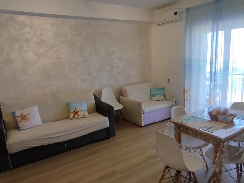 a living room with a couch and chairs and a table at Stella Marina in Giardini Naxos