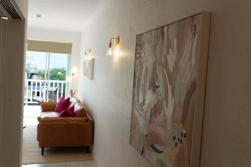 a painting hanging on a wall in a living room at CASA PAPAYA Adults Only Apartment in Port Douglas