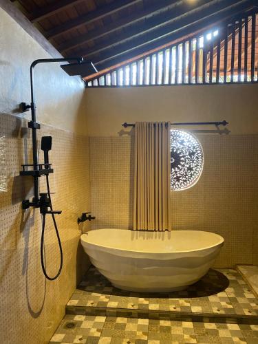 a bathroom with a large tub and a shower at Lembah Cinta Mayungan in Baturiti