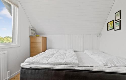 a white bed in a room with a window at Holiday Home Følfodvej Rønde Ii in Rønde