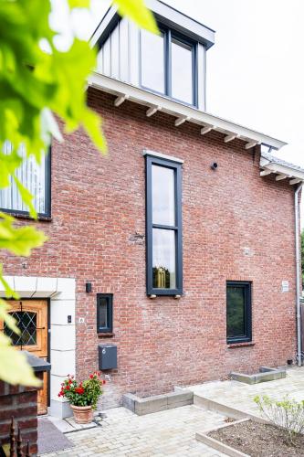 a brick house with black windows at BB aan de kapel in Roermond