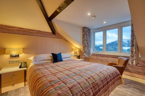 安布尔塞德Ambleside Salutation Hotel & Spa, World Hotel Distinctive的一间卧室，配有一张床、一张书桌和一扇窗户