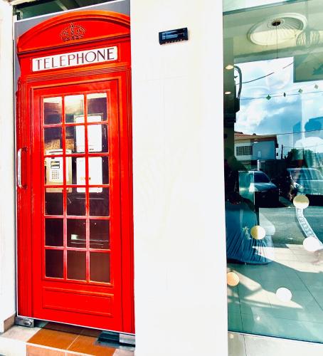 a red telephone booth on the side of a building at N HIBISCUS HOTEL in Seri Kembangan