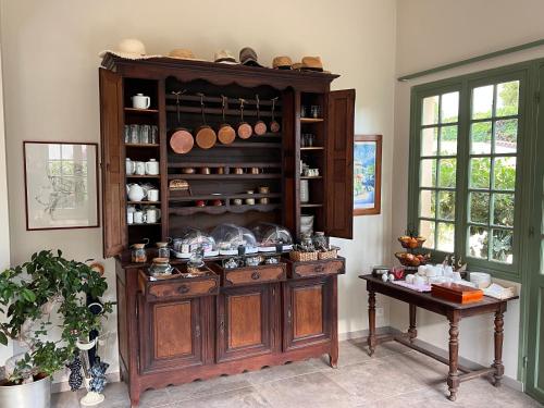 a kitchen with a large wooden cabinet with pots and pans at Hotel Le Ponteil in Antibes