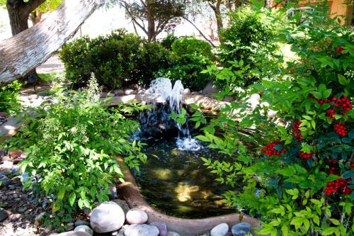 a fountain in a garden with plants and flowers at Sky Ranch Lodge in Sedona