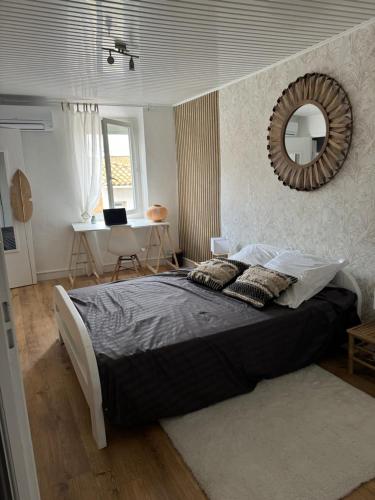 une chambre avec un grand lit et un miroir dans l'établissement Duplex moderne centre du Boulou, au Boulou
