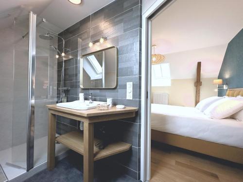 une salle de bain avec un lavabo et une douche et un lit dans l'établissement Ker Benouic jolie demeure bretonne 6 personnes, à Bourg-Blanc