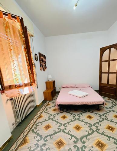 a room with a bed and a window and a rug at Casa Odry in Massa