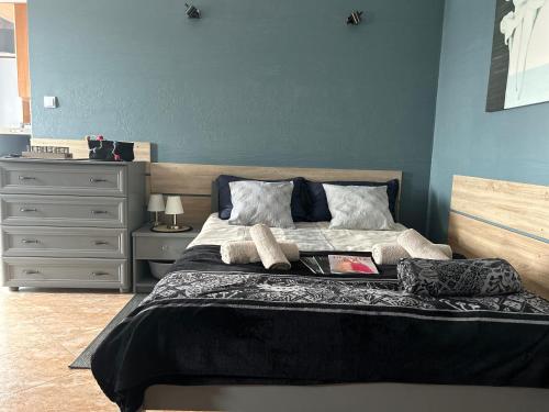 a bedroom with a large bed with a blue wall at Apartament na nowej starówce in Kołobrzeg