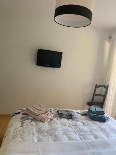 a bedroom with a bed with a tv on the wall at Comme sur un nuage, appartement pour 4 personnes in Nendaz