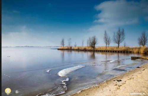 a large body of water with ice on the shore at Jan in Steendam